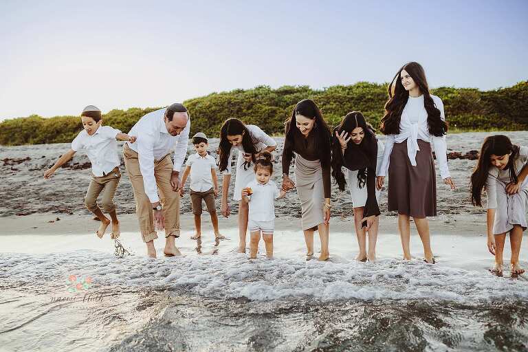 Kids playing in the waves during large family beach photo shoot Boca Raton