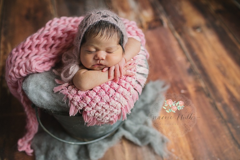 Newborn baby girl in pink in Naomi Bluth's newborn photo studio.