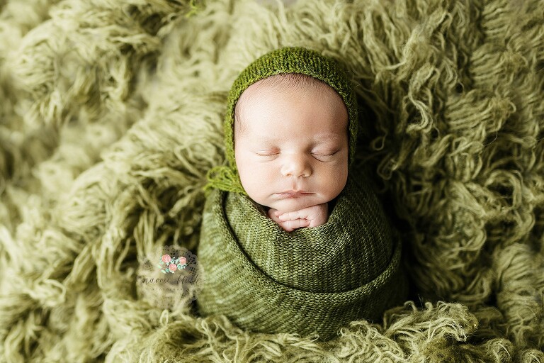 Newborn baby boy swaddled in green wrap during a natural newborn photo shoot in Boca.