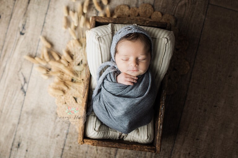 Newborn baby in soft wrap during gentle posing session with Naomi Bluth Photography in Boca Raton.